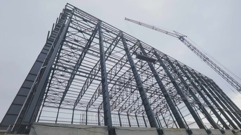 Construction of an industrial building. Metal frame of an industrial building. Construction of a large warehouse for a factory