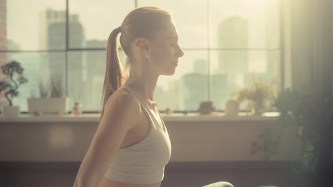 Young Beautiful Female Exercising, Practising Meditation in the Morning in Her Bright Sunny Loft Apartment. Healthy Lifestyle, Fitness, Wellbeing and Mindfulness Concept.