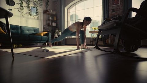 Young Beautiful Female Exercising, Stretching and Practising Yoga in the Morning in Her Bright Sunny Loft Apartment. Healthy Lifestyle, Fitness, Wellbeing and Mindfulness Concept.