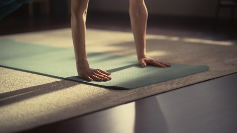 Close Up of Athletic Young Female Exercising, Stretching and Doing Yoga in the Morning in Her Bright Sunny Room at Home. Beautiful Woman in Sports Clothes Practising Different Asana Poses on the Mat.