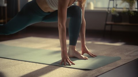 Close Up of a Young Athletic Woman Exercising, Stretching and Practising Yoga in the Morning in Her Bright Sunny Home Living Room. Healthy Lifestyle, Fitness, Wellbeing and Mindfulness Concept.