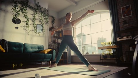 Athletic Young Female Exercising, Stretching and Doing Yoga in the Morning in Her Bright Sunny Room at Home. Beautiful Woman in Sports Clothes Practising Different Asana Poses on the Mat.