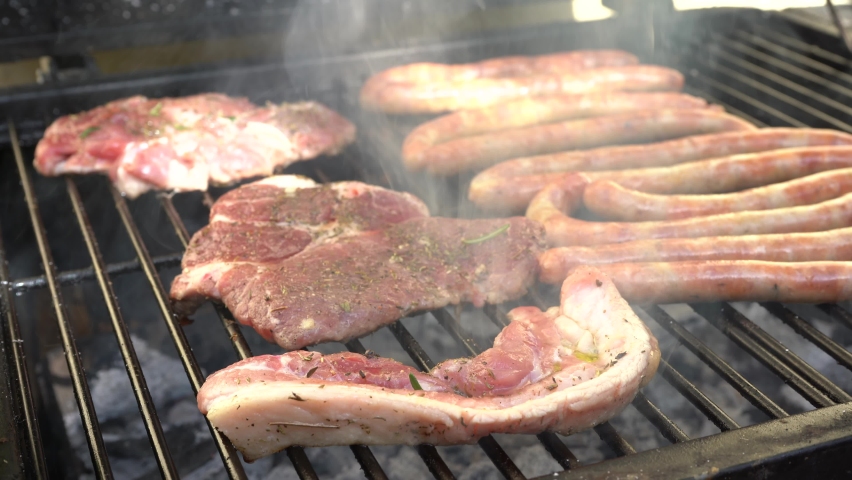Sausages and steak on the grill. Selective focus. 4k video. | Shutterstock HD Video #1090363449