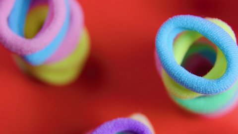 super macro of a rubber bands close up very colorful rotating colors red background, group magnificent circular textile hair elastic, 4K selective focus footage
