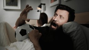 Soccer fan. Bearded male fan watching soccer online broadcast. Spectator of football match screams with happiness - Powered by Shutterstock - Get 15% off with code: PIKWIZARD15