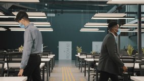 Indian man meet worker african businessman wear medical face masks greeting in office workspace hall waving hands no touching palms two male colleagues avoid spreading of coronavirus in corporate work - Powered by Shutterstock - Get 15% off with code: PIKWIZARD15