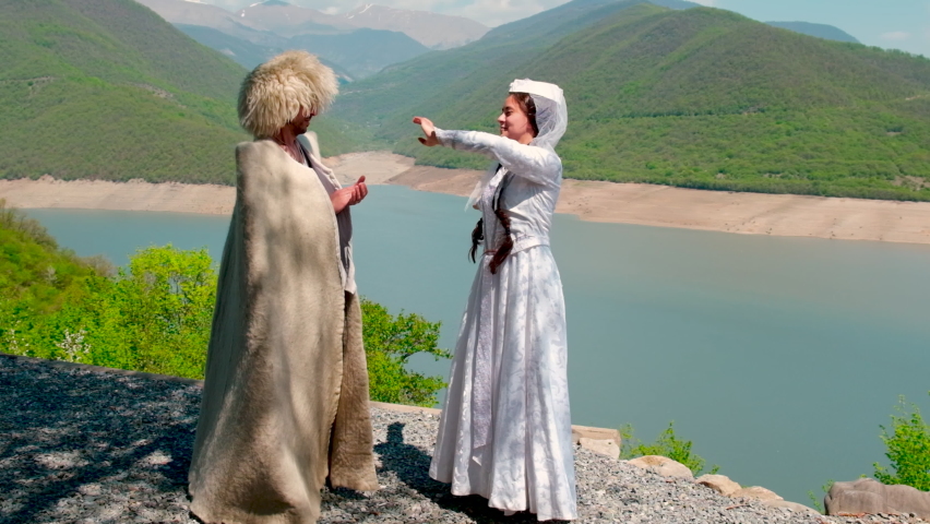 A girl and a man in a papakha and national Georgian costume. Selective focus.