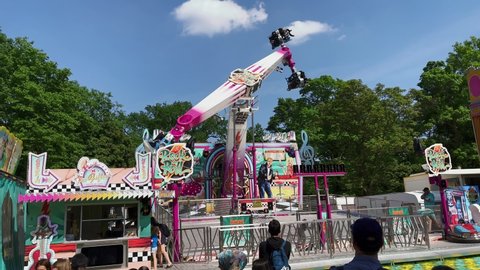 BERLIN, GERMANY - MAY 15, 2022: Carnival Thrill Ride ROCK AND ROLL spinning at Fun Fair, Carnival Neukoellner Maientage in the public park Hasenheide. With Sound.