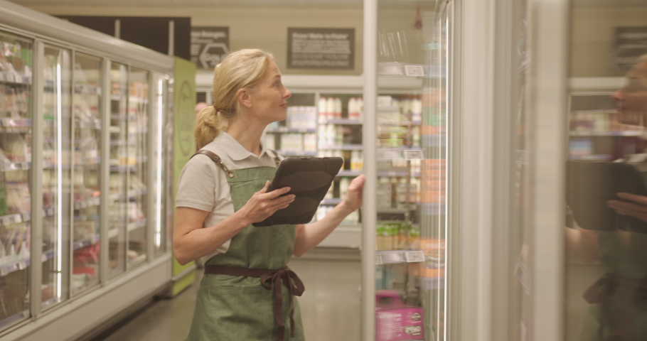 Supermarket Employee Taking Inventory Using Digital tablet in Store Royalty-Free Stock Footage #1090372609