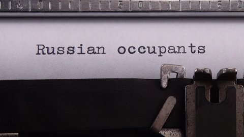 Typing phrase "Russian occupants" on retro typewriter.
