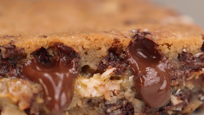 Macro close up of gooey blondie brownie with melted chocolate 4k pan left caramel and coconut Royalty-Free Stock Footage #1090378035