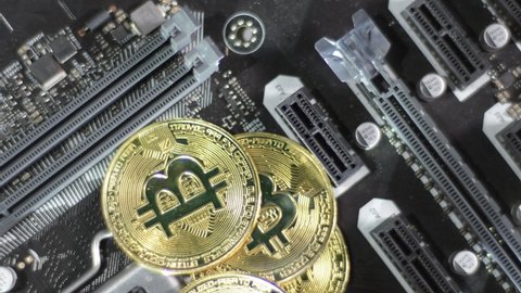 Bitcoin BTC coins rotate on black circuit motherboard. Digital money, flashing white light