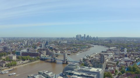 Slider drone shot of Tower bridge and canary wharf on a sunny day
