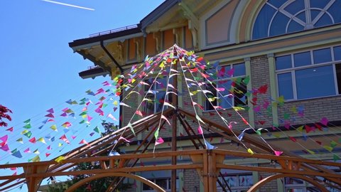 Small colorful flags blowing in the wind at hotel named Uto Kulm on a sunny spring day. Slow motion movie shot May 18th, 2022, Zurich, Switzerland.