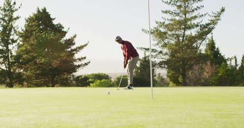 Video of african american man playing golf on golf field. sporty, active lifestyle and playing golf concept.