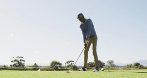 Video of african american man playing golf on golf field. sporty, active lifestyle and playing golf concept.