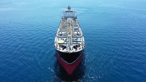 Aerial drone tracking video of huge crude oil tanker cruising in open ocean deep blue sea