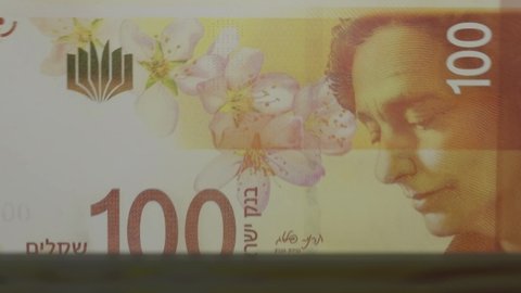100 Israeli shekels banknotes in cash machine. Israeli cash counting video. Financial and business concept.