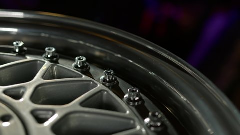 Close up view of three-piece forged wheels with classic pattern. Beautiful rims with chrome-plated shiny shelf with perfect polished bolts are spinning.