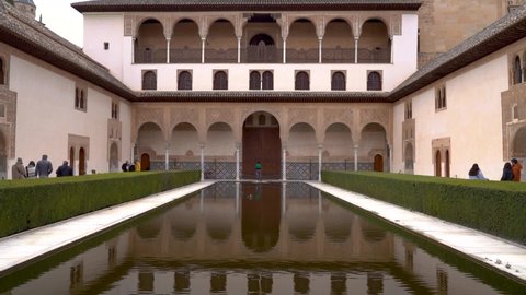 Granada , Spain - 02 25 2022: Slow motion tilt up over water pond reflections inside Alhambra Palace in Spain
