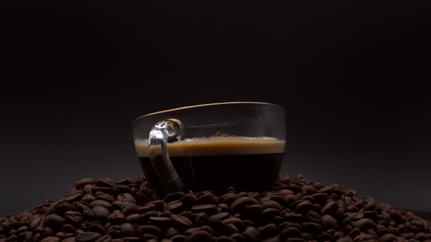 Close Up Cup Black Coffee On Roasted Coffee Bean On Black Background. | Shutterstock HD Video #1090395425