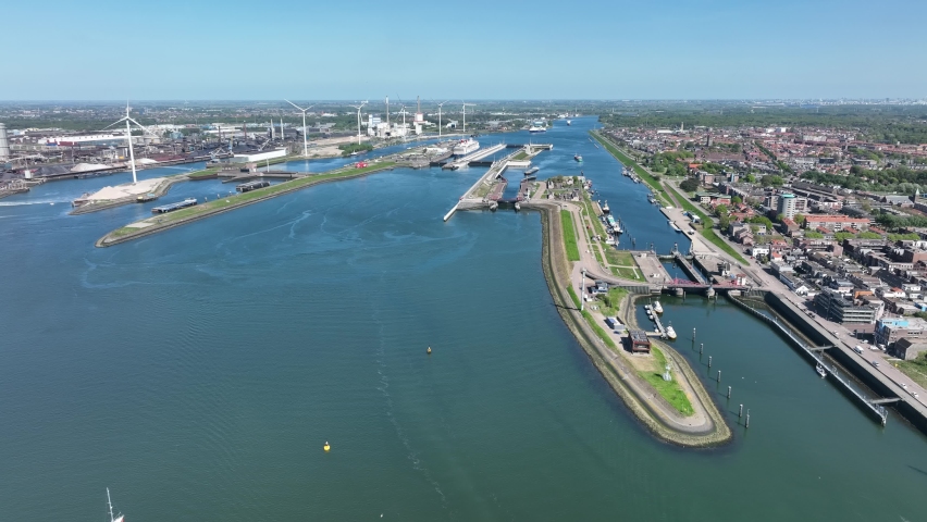 4k aerial video of cruise ship leaving large sea sluice towards Amsterdam in the Netherlands. Tata steel factory in the back ground