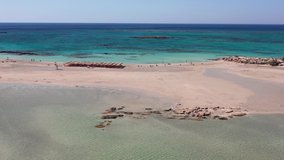 Aerial view video from sideways moving drone on Elafonisi sandy beach on Crete. Elafonissi is one of the most known world beaches with pink sand. Kissamos, Chania prefecture, Crete Island, Greece.