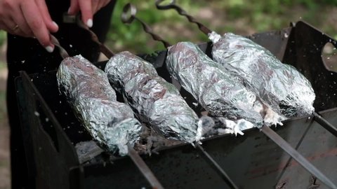 Shish kebab in foil on the grill. Shish kebab cooked in charcoal. Cooking in nature.