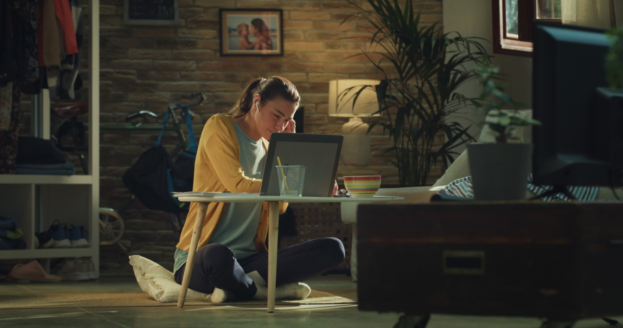 Cinematic shot of young woman is making video conference call to colleagues or partners with laptop while doing smart working from home during lockdown. Royalty-Free Stock Footage #1090398511