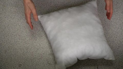 a person checks for elasticity a white pillow