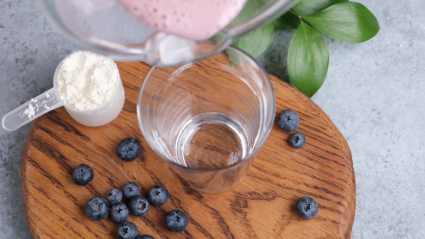 Pouring berry smoothie in glass in slow motion Royalty-Free Stock Footage #1090407369