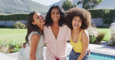 Portrait of happy diverse female friends smiling at swimming pool party. spending quality time at home.