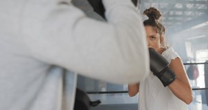 Video of fit diverse woman and man boxing at gym. active, fit, sporty and healthy lifestyle, exercising at gym concept.