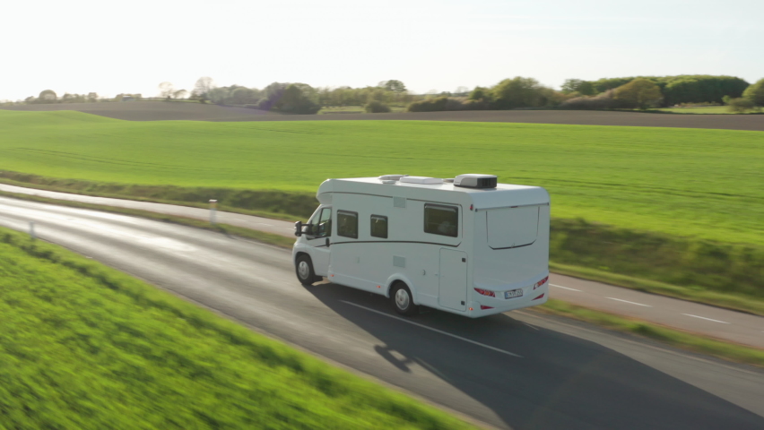 Wide Drone Flight Tracking Campervan Driving Along Road Through Green Fields, Denmark Royalty-Free Stock Footage #1090414809