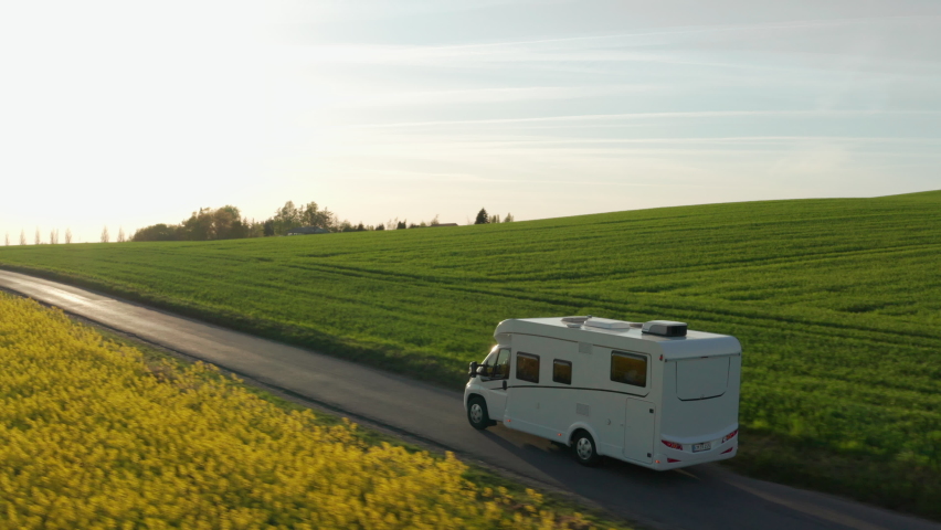 Wide Drone Flight Tracking Campervan Driving Along Road Through Green And Yellow Fields, Denmark Royalty-Free Stock Footage #1090414823