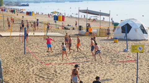 Samara, Russia - circa March, 2022: A group of people playing beach volleyball on the sand