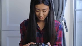 Young asian girl browsing photos on professional camera. Vietnamese photographer woman browse images on dslr. Cute Southeast Asian person using modern photocamera. BIPOC person lifestyle video clip  