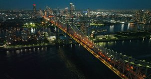 Tremendous multicolored lights of night New York. Bridge crossing the river full of traffic. Top view.