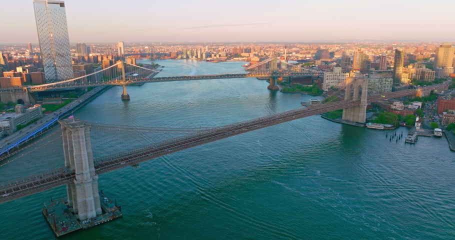 Two huge bridges crossing East river. Flying over the blue waters flowing through the fantastic New York city. Royalty-Free Stock Footage #1090419039