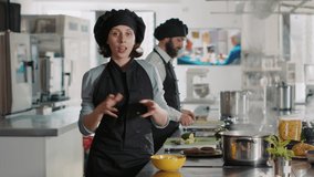 POV of female chef teaching gastronomy on cooking show, filming culinary class video on camera. Professional cook in uniform talking about meal preparations and gourmet dish. Handheld shot.