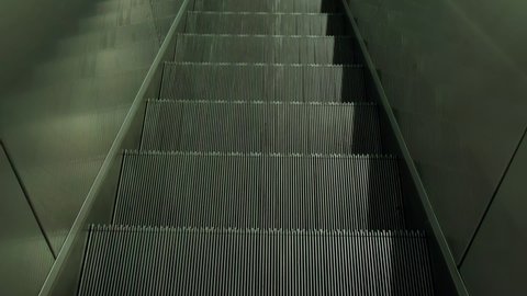 FPV First person view of moving empty escalator stairs, escalator moves steps down