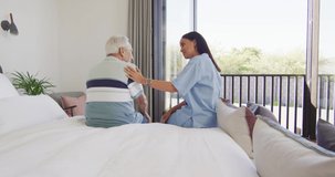 Animation of biracial female doctor and caucasian senior man talking. seniors health and nursing home lifestyle concept digitally generated video.
