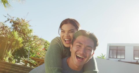 Video of happy diverse couple talking and embracing in garden. leisure, relax, lifestyle and spending time together at home and garden concept. วิดีโอสต็อก