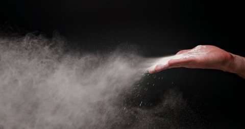 White flour powder flying against dark background
