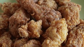 Close up view 4k stock video footage of fresh hot crispy delicious fried chicken pieces. Set of chicken snacks isolated spinning around. Food background
