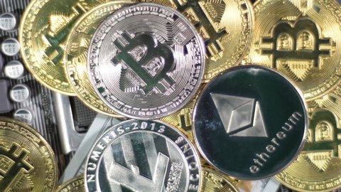 Multiple crypto currencies: Litecoin LTC, Ethereum ETH and Bitcoins BTC on circuit board. Rotate shot