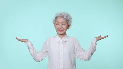 Asian senior woman comparing two things.