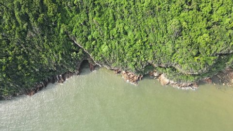 Surface Ocean waves on the beach rocks on a bright summer day at Hua Hin beach in Thailand, aerial view drone shot.