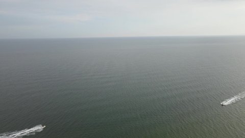 Aerial view drone shot, Panorama view motorboat sailing fast on a bright summer time at tropical Hua Hin beach in Thailand.