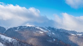 Scenic Aerial View of High Mountains Peaks Range. Epic Landscape in Sunny Winter Day. Time Lapse Video with Blue Sky, Fog and Snow. 4K Background Pan Shot of Carpathian Mountain in Ukraine